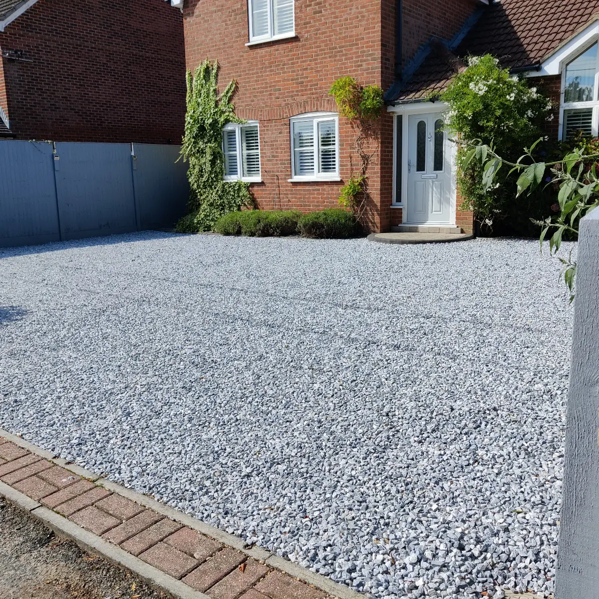 Grey shingle driveway with a block edge