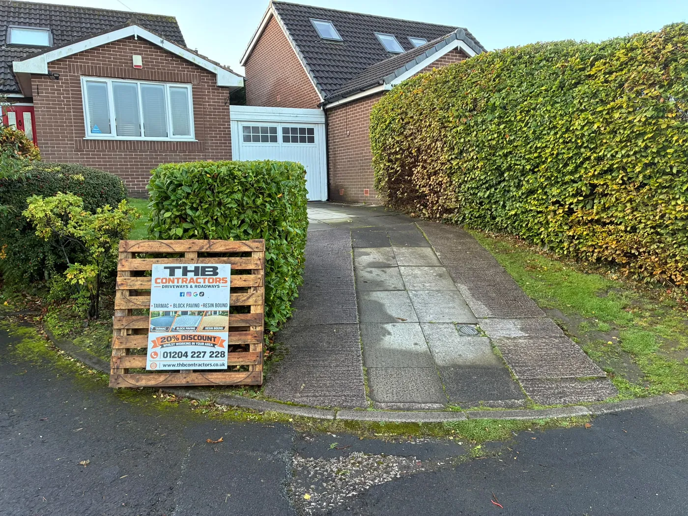 Before: a worn concrete drive replaced with a herringbone block paved driveway and a charcoal border.