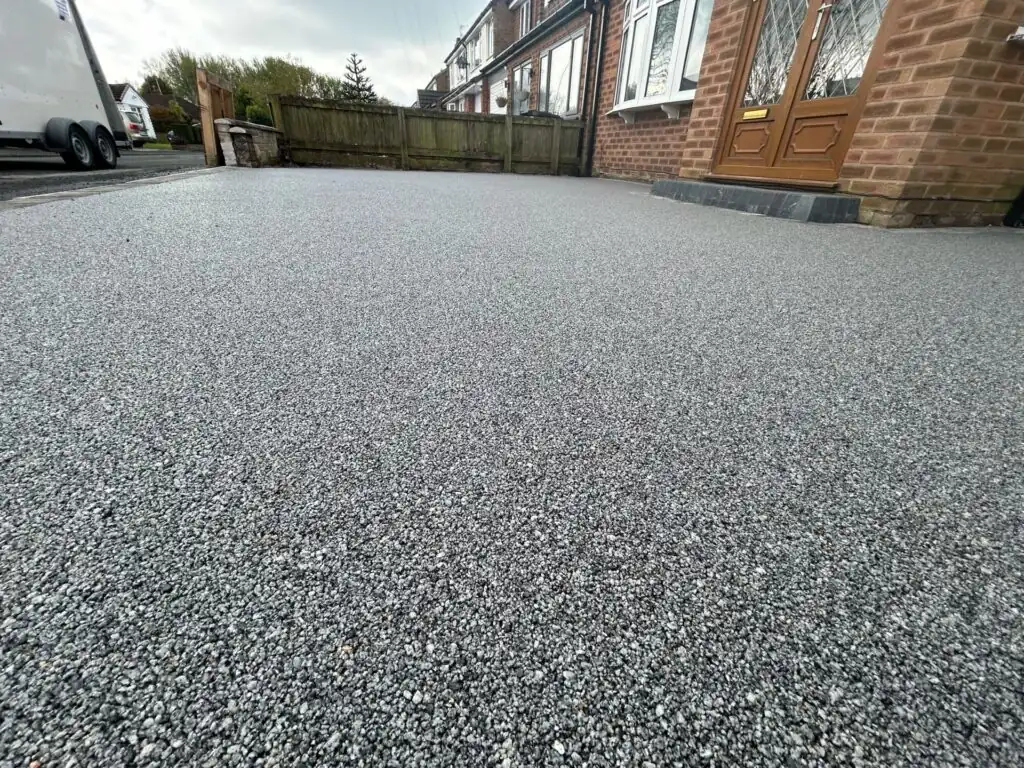 Grey resin bound driveway laid up to the front door, the stone texture of the surface visible close up
