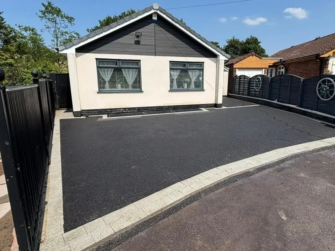 Newly laid tarmac driveway edged with a light block border, running the full width of a bungalow frontage