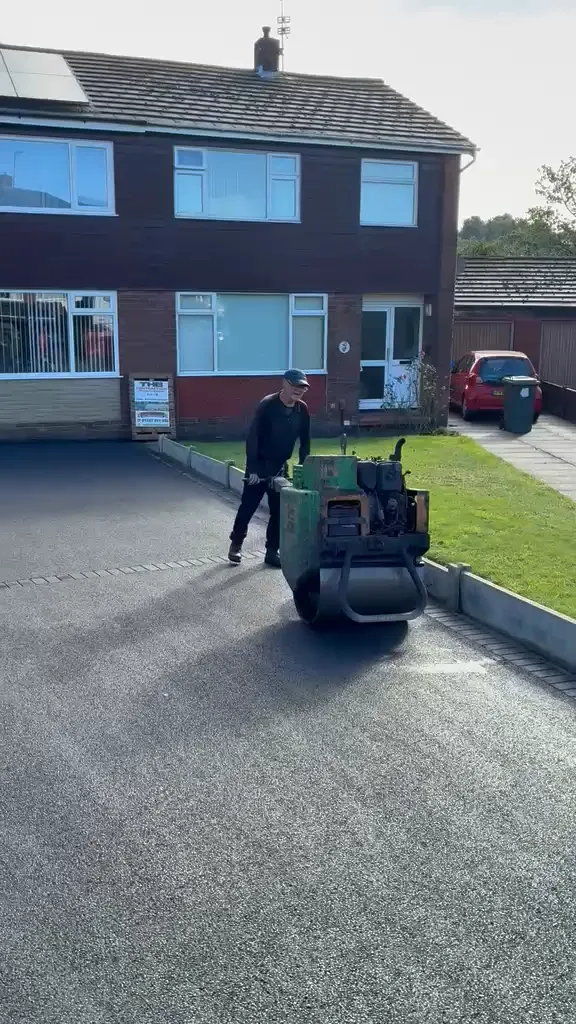 Rolling a freshly laid tarmac driveway